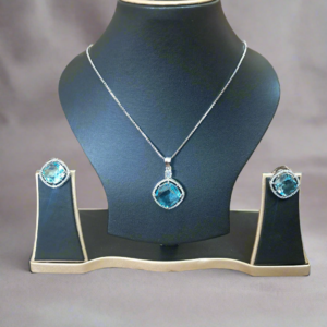 Aqua Blue Pendant Set with CZ studs and silver-plated chain displayed elegantly on a black jewelry stand.